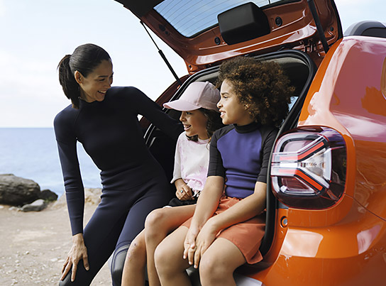 Une famille adossée à sa voiture Dacia